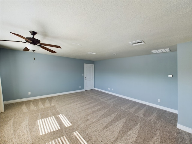 carpeted empty room featuring visible vents, a textured ceiling, and baseboards