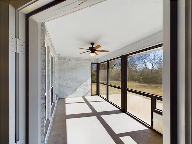 unfurnished sunroom featuring ceiling fan