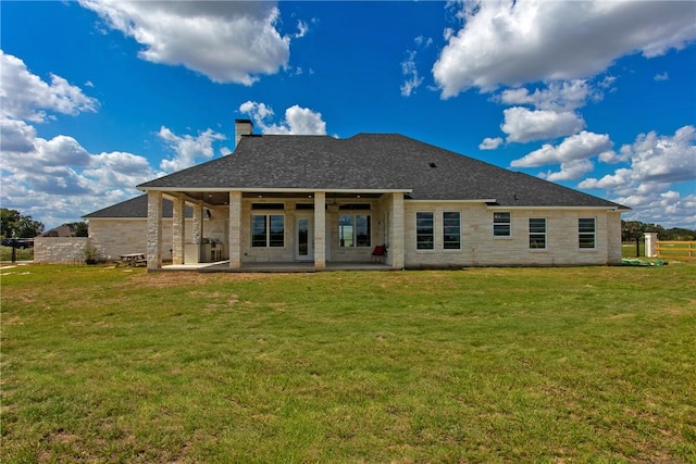 back of house with a patio and a lawn