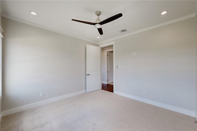 carpeted empty room with ceiling fan and crown molding