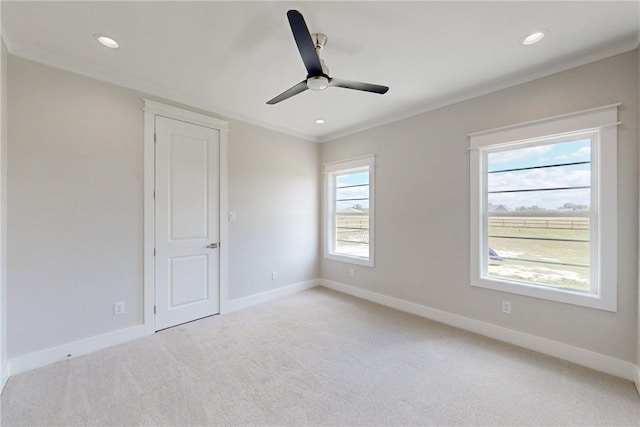 unfurnished room featuring light carpet, ceiling fan, and ornamental molding