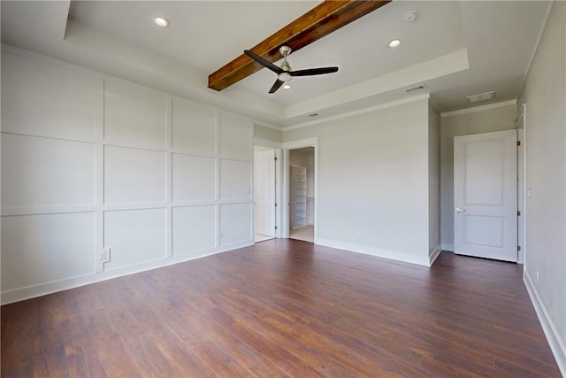 empty room with a tray ceiling, beamed ceiling, and dark wood-type flooring