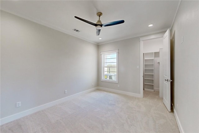 unfurnished bedroom with light carpet, a closet, a spacious closet, and ceiling fan