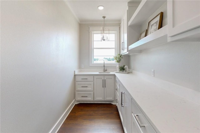 kitchen featuring decorative light fixtures, white cabinetry, sink, and dark wood-type flooring