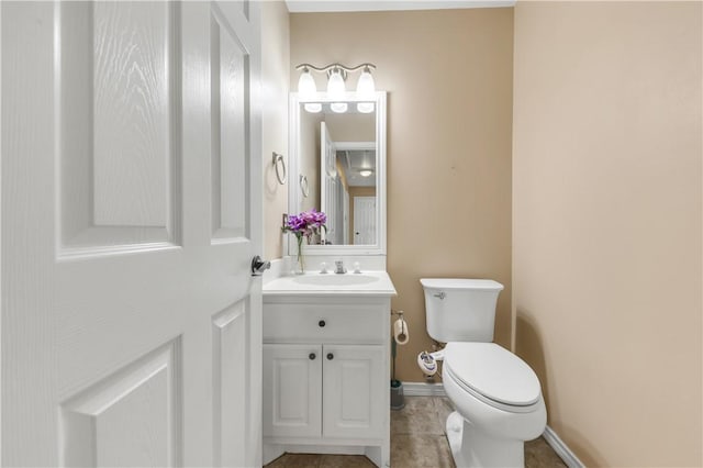 half bath featuring toilet, baseboards, and vanity