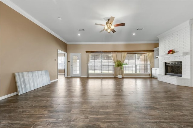 unfurnished living room featuring a brick fireplace, a healthy amount of sunlight, visible vents, and dark wood-style flooring