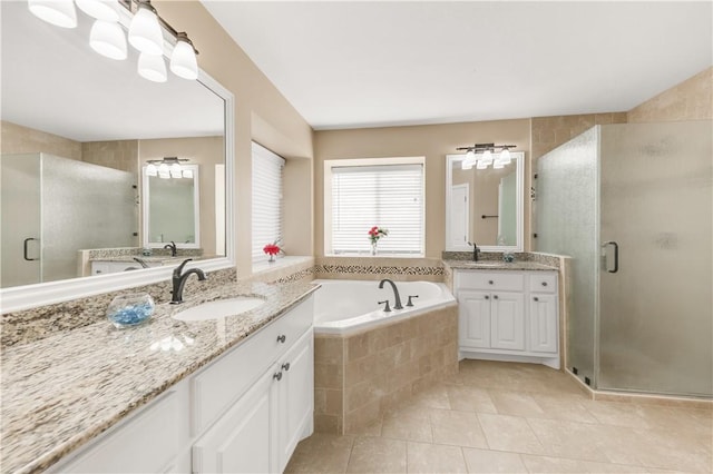 full bathroom with two vanities, a sink, a shower stall, tile patterned flooring, and a bath