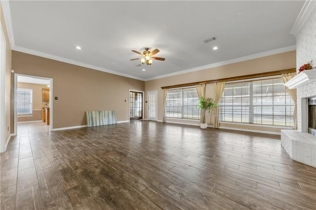 unfurnished living room featuring ornamental molding, a fireplace, wood finished floors, and visible vents