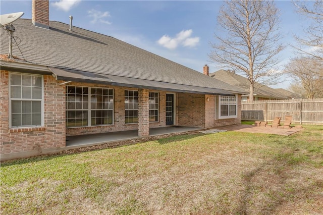 rear view of property featuring a chimney, a patio area, and fence