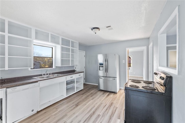 kitchen featuring range with electric stovetop, sink, stainless steel fridge, white dishwasher, and light hardwood / wood-style floors