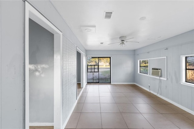 tiled spare room featuring brick wall, cooling unit, and ceiling fan