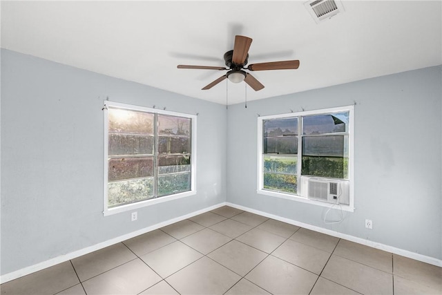 empty room featuring a healthy amount of sunlight, light tile patterned floors, and ceiling fan