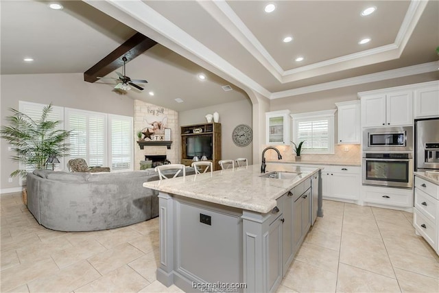 3549 Foxcroft Path, Bryan, TX 77808 - kitchen with stainless steel appliances, a ceiling fan, a kitchen island with sink, open floor plan, and decorative backsplash