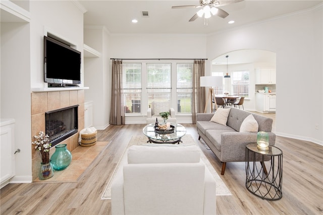 3107 Pleasant Forest Dr, College Station, TX 77845 - living room featuring light wood-style flooring, healthy amount of natural light, a fireplace, a ceiling fan, and ornamental molding