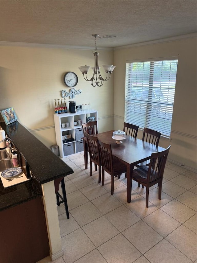 152 Forest Dr, College Station, TX 77840 - dining area featuring ornamental molding, a chandelier, light tile patterned flooring, and a textured ceiling