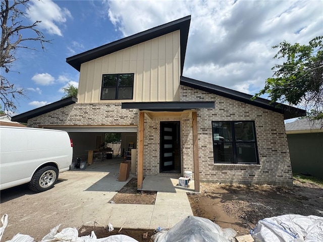 807 S Coulter Dr, Bryan, TX 77803 - view of front of home with brick siding, board and batten siding, and driveway
