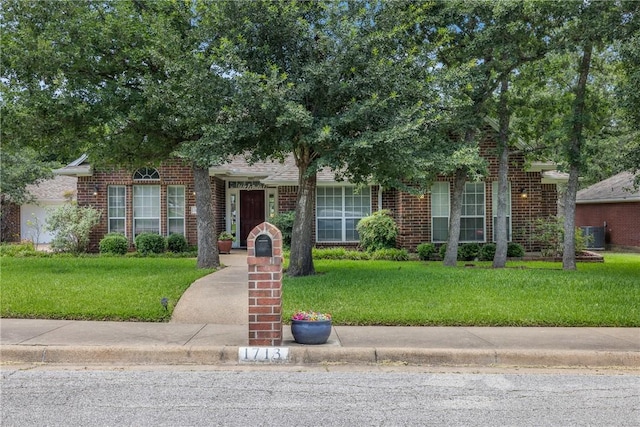 1713 Cardinal Ln, College Station, TX 77845 - view of property hidden behind natural elements featuring a front lawn and brick siding