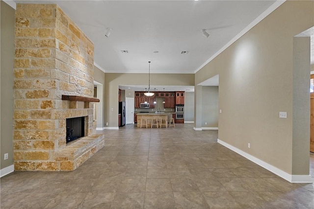 unfurnished living room with visible vents, a fireplace, crown molding, and baseboards