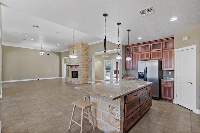 kitchen with visible vents, a fireplace, stainless steel fridge with ice dispenser, and crown molding