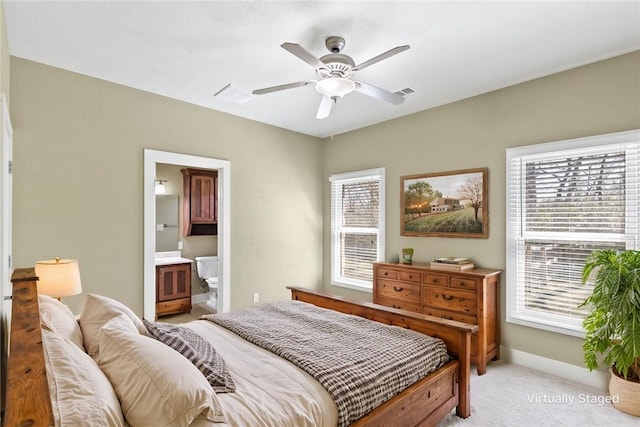 bedroom featuring connected bathroom, a ceiling fan, baseboards, and light carpet