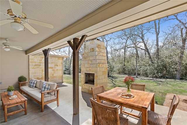 view of patio featuring an outdoor living space with a fireplace, outdoor dining area, and ceiling fan