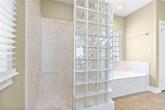 bathroom featuring tile patterned flooring, a walk in shower, and a garden tub