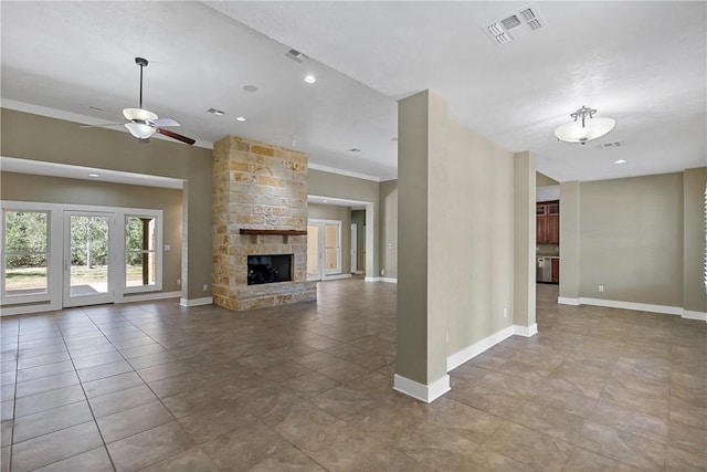 unfurnished living room featuring visible vents, a stone fireplace, baseboards, and a ceiling fan