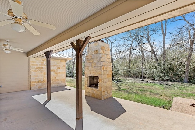 view of patio with an outdoor stone fireplace and ceiling fan