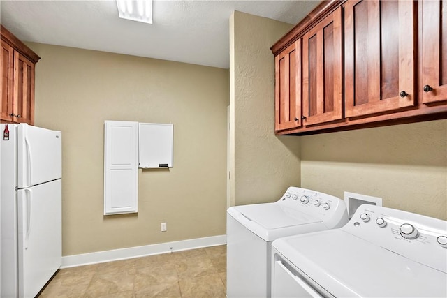 laundry area featuring cabinet space, independent washer and dryer, and baseboards