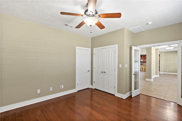 unfurnished bedroom with visible vents, baseboards, and wood finished floors