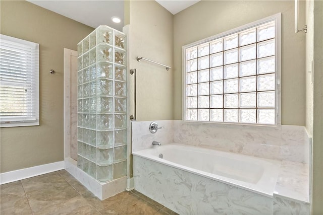 bathroom featuring tile patterned flooring, a garden tub, baseboards, and walk in shower