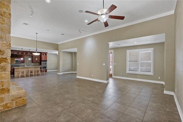 unfurnished living room featuring crown molding, baseboards, visible vents, and ceiling fan