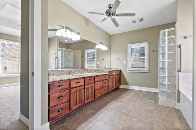 full bathroom with a sink, visible vents, tiled shower, and a wealth of natural light