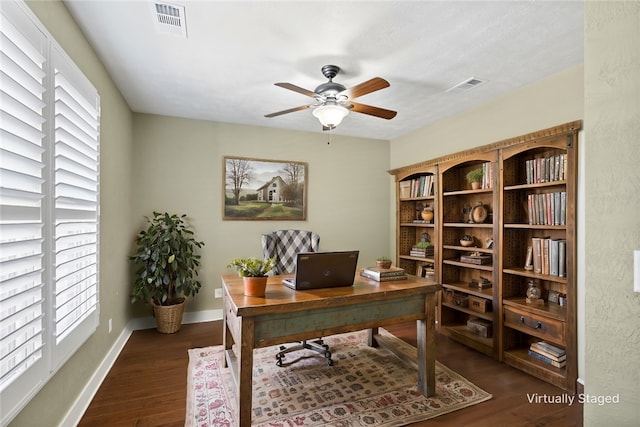 office area featuring baseboards, visible vents, dark wood-style flooring, and ceiling fan