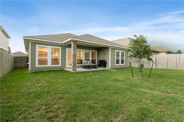 rear view of property featuring a lawn, a patio area, and a fenced backyard