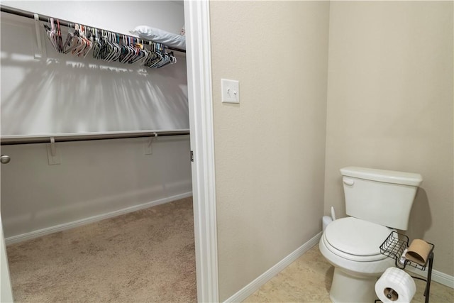 bathroom with toilet and baseboards