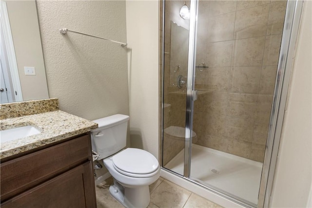 bathroom featuring a stall shower, toilet, tile patterned floors, vanity, and a textured wall