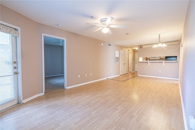 519 SW Pkwy Unit 203, College Station, TX 77840 - unfurnished living room featuring light wood-type flooring, a ceiling fan, a chandelier, and baseboards