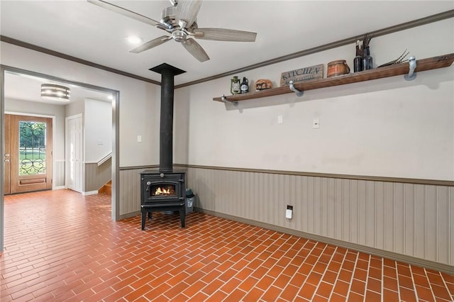 2355 Jackson League Cir, Brenham, TX 77337 - unfurnished living room with brick patterned flooring, a wood stove, ceiling fan, and ornamental molding