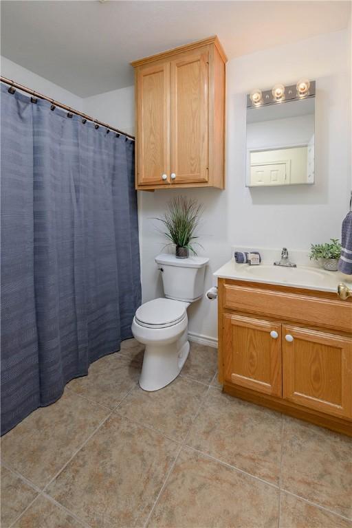 full bathroom featuring vanity, tile patterned floors, and toilet