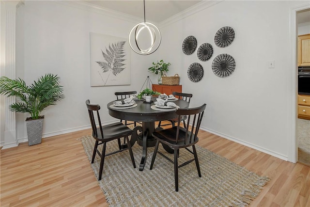 dining area featuring baseboards, light wood-style floors, and ornamental molding