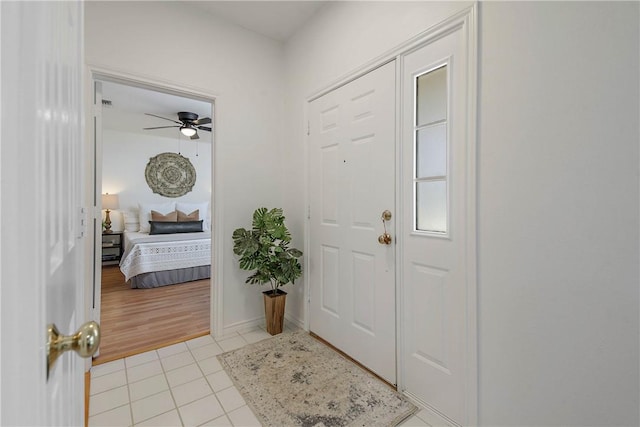 foyer featuring light tile patterned floors and ceiling fan