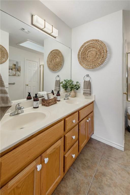 full bathroom featuring tile patterned floors, visible vents, double vanity, and a sink