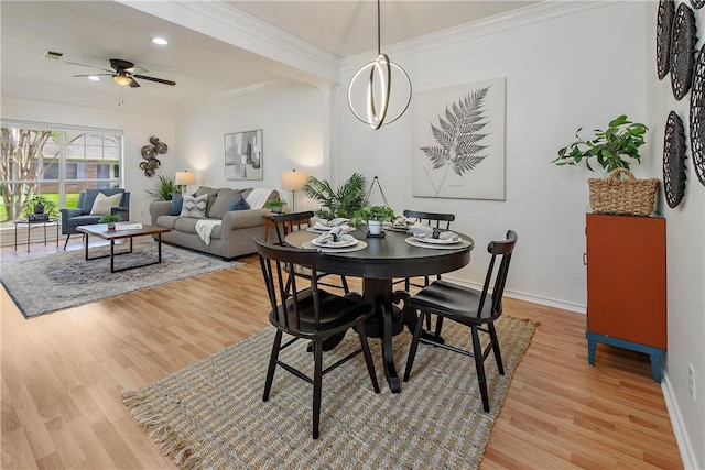 dining room featuring visible vents, crown molding, light wood-type flooring, and baseboards