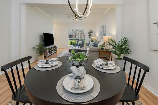 dining area featuring light wood-type flooring, baseboards, ornamental molding, and a chandelier