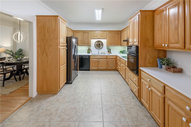 kitchen featuring light tile patterned floors, ornamental molding, a sink, black appliances, and light countertops