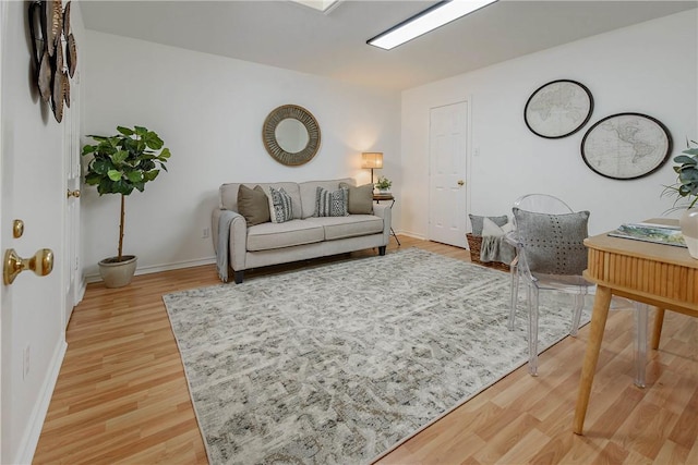 living area featuring baseboards and light wood-style flooring