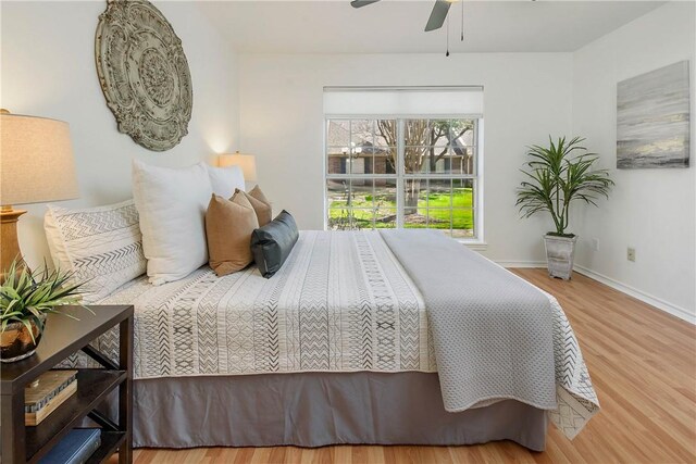 bedroom featuring ceiling fan, baseboards, and wood finished floors