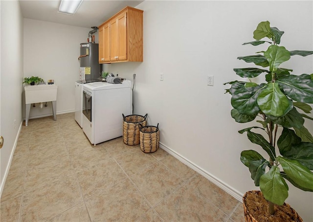 clothes washing area featuring washer and dryer, water heater, cabinet space, light tile patterned floors, and baseboards