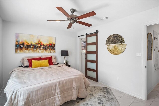 3004 Woodville Rd, Bryan, TX 77803 - bedroom with a barn door, ceiling fan, and baseboards